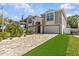 Attractive two-story home with a paver driveway, lush grass, and double-car garage at 314 Crosswinds Dr, Palm Harbor, FL 34683