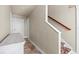 Bright hallway featuring a staircase with carpeted steps, white wainscoting and a hardwood handrail at 314 Crosswinds Dr, Palm Harbor, FL 34683