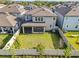 Aerial view of a fenced backyard, screened patio, and modern two-story home at 33263 Sycamore Leaf Dr, Wesley Chapel, FL 33545