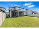 Spacious backyard with green grass, screened in patio, and a white fence at 33263 Sycamore Leaf Dr, Wesley Chapel, FL 33545