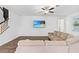 Bright living room with built-in wall unit, large sectional sofa, and wood floors at 33263 Sycamore Leaf Dr, Wesley Chapel, FL 33545