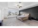 This main bedroom has a carpeted floor, a ceiling fan, a dark accent wall, and a window at 33263 Sycamore Leaf Dr, Wesley Chapel, FL 33545