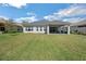 Spacious backyard with a well-maintained lawn and a covered patio for outdoor living at 34516 Heavenly Ln, Dade City, FL 33525