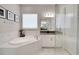 A luxurious bathroom features a soaking tub, glass shower, and white marble accents at 34516 Heavenly Ln, Dade City, FL 33525