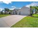 Beautiful single-story home boasts a well-manicured lawn, two-car garage, and vibrant landscaping at 34516 Heavenly Ln, Dade City, FL 33525