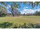 Scenic view of a lush green golf course surrounded by mature trees under a sunny sky at 34516 Heavenly Ln, Dade City, FL 33525