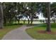 Beautiful golf course view with a walking path, mature trees, and a pond at Lake Jovita Golf & Country Club at 34516 Heavenly Ln, Dade City, FL 33525