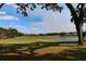 Scenic golf course with a pond and green lawns, complemented by a clear blue sky at Lake Jovita Golf & Country Club at 34516 Heavenly Ln, Dade City, FL 33525