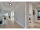 Hallway features modern lighting, wood floors and a view into the living space and laundry room at 34516 Heavenly Ln, Dade City, FL 33525