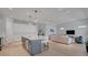 Modern kitchen open to the living room with a gray kitchen island and white cabinetry at 34516 Heavenly Ln, Dade City, FL 33525