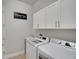Well-organized laundry room with modern appliances, white cabinetry, and a convenient sink at 34516 Heavenly Ln, Dade City, FL 33525