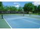Enjoy the community's blue tennis courts surrounded by mature trees and well-maintained fencing at 34516 Heavenly Ln, Dade City, FL 33525