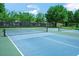 Enjoy the community's blue tennis courts surrounded by mature trees and well-maintained fencing at 34516 Heavenly Ln, Dade City, FL 33525