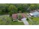 Aerial view of a well-maintained single Gathering home with mature trees, a driveway, and a peaceful neighborhood at 34527 Cedarfield Dr, Dade City, FL 33523