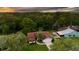 An aerial view of a single Gathering home nestled in a lush, green neighborhood at sunset at 34527 Cedarfield Dr, Dade City, FL 33523