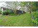 A lush green backyard featuring well-maintained lawn and a screened-in patio, perfect for outdoor relaxation at 34527 Cedarfield Dr, Dade City, FL 33523