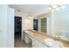 Bathroom with double sinks, a large mirror, and access to the bedroom and closet at 34527 Cedarfield Dr, Dade City, FL 33523