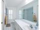 White bathroom featuring a large mirror and a shower/tub combo at 34527 Cedarfield Dr, Dade City, FL 33523