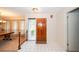 Bright foyer featuring tile flooring, a wooden front door, and a glimpse into the dining area at 34527 Cedarfield Dr, Dade City, FL 33523