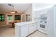 Compact kitchen with white appliances and counters, showcasing an efficient cooking space near the breakfast nook at 34527 Cedarfield Dr, Dade City, FL 33523