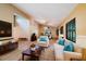 Bright living room with vaulted ceilings, comfortable seating, decorative shutters, and a view into the dining area at 34527 Cedarfield Dr, Dade City, FL 33523