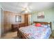 Cozy bedroom with wood paneling, ceiling fan, and ample natural light for restful nights at 37025 Lois Ave, Zephyrhills, FL 33542