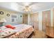 Bedroom features comfortable queen bed, ceiling fan, and convenient access to closets at 37025 Lois Ave, Zephyrhills, FL 33542