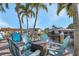 Outdoor seating and fire pit on a wooden dock surrounded by palm trees on a sunny day at 3819 Barnegat Dr, Punta Gorda, FL 33950