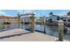 Private boat dock with a boat lift surrounded by calm water and nearby houses at 3819 Barnegat Dr, Punta Gorda, FL 33950