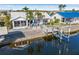 Waterfront home featuring a private boat dock, tropical landscaping, and outdoor seating area at 3819 Barnegat Dr, Punta Gorda, FL 33950