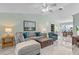 Open-concept living room with a comfortable sofa, tile flooring, and a ceiling fan at 3819 Barnegat Dr, Punta Gorda, FL 33950