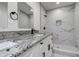 Stylish bathroom with a double granite vanity top and sleek walk-in shower with marble tiling at 3841 Wahoo Se Dr, St Petersburg, FL 33705