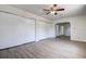 Open bedroom with wood-look flooring, a ceiling fan, and sliding closet doors at 3841 Wahoo Se Dr, St Petersburg, FL 33705