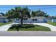 Charming single-story home featuring a large tree and a well-manicured front lawn at 3841 Wahoo Se Dr, St Petersburg, FL 33705