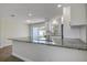 Open-concept kitchen featuring a large island with granite countertops and stylish white cabinets at 3841 Wahoo Se Dr, St Petersburg, FL 33705