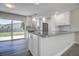 Open-concept kitchen featuring a large island with granite countertops and stylish white cabinets at 3841 Wahoo Se Dr, St Petersburg, FL 33705