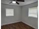 Bedroom with wood-look flooring, ceiling fan, and two windows at 3918 E Clifton St, Tampa, FL 33610