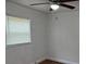 A cozy bedroom featuring a ceiling fan, wood floors, and a window with natural light at 3918 E Clifton St, Tampa, FL 33610