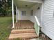 Close-up of a covered front porch featuring wooden flooring and steps leading to the entrance at 3918 E Clifton St, Tampa, FL 33610