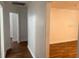 A hallway showcasing hardwood floors and access to multiple rooms in the home at 3918 E Clifton St, Tampa, FL 33610