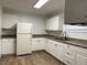 A bright kitchen with white cabinets, granite countertops, and wood-look flooring at 3918 E Clifton St, Tampa, FL 33610