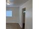 A living room with white walls, wood-look flooring, and a window at 3918 E Clifton St, Tampa, FL 33610