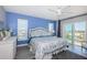 Inviting bedroom with a queen bed, white wicker accents, light grey floors, and balcony with a stunning view at 4900 Brittany S Dr # 502, St Petersburg, FL 33715