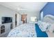 Spacious bedroom featuring a bed with a blue headboard, a tv, and ensuite bathroom and desk at 4900 Brittany S Dr # 502, St Petersburg, FL 33715