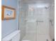 Elegant shower with tile surround, grab bar, and glass doors in well lit primary bathroom at 4900 Brittany S Dr # 502, St Petersburg, FL 33715