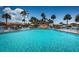 Sparkling community swimming pool with lounge chairs, umbrellas, and manicured landscaping at 4900 Brittany S Dr # 502, St Petersburg, FL 33715