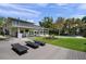 Relaxing backyard featuring a pool, manicured lawn, patio with lounge chairs and lush landscaping at 5018 S The Riviera St, Tampa, FL 33609