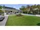 A manicured backyard with artificial turf, a modern house and a sparkling pool with brick trim at 5018 S The Riviera St, Tampa, FL 33609
