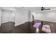 Open home gym with dark wood floors, neutral walls and white trim, featuring exercise mats and equipment at 5018 S The Riviera St, Tampa, FL 33609