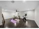 Spacious home gym featuring dark hardwood floors, a ceiling fan, and two windows providing natural light at 5018 S The Riviera St, Tampa, FL 33609